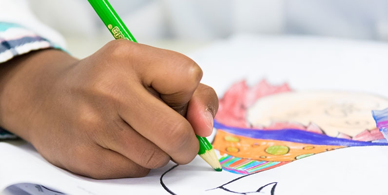 Telling Tales Contest hand of child drawing using pencil crayons