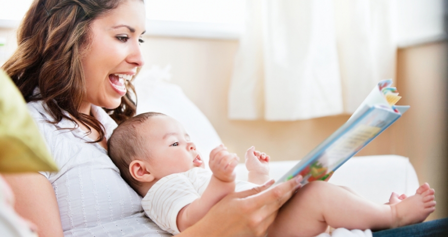 Baby Storytime Mother reading a book to her baby that is sitting in her lap