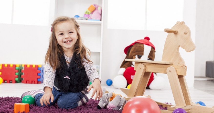 Baby Play Date little girl sitting on the floor with toys around her