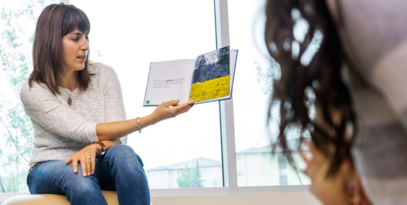 Woman reading a book to a group of children