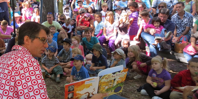 Community Man reading a story to a group of children at the Telling Tales Festival