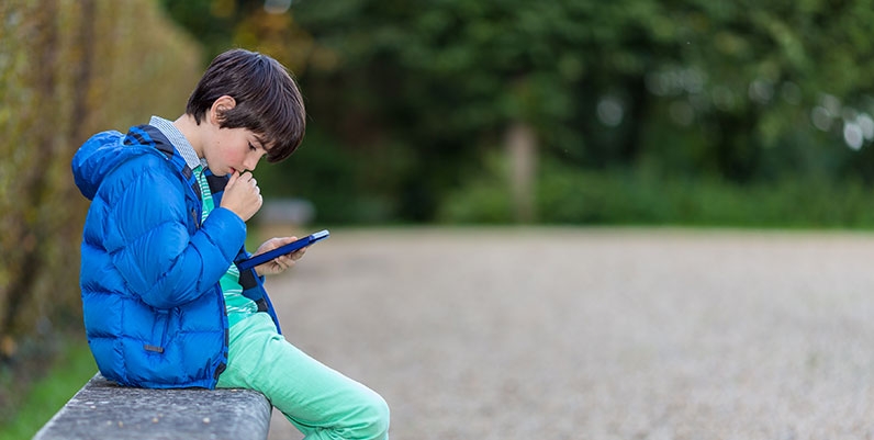 Libby boy reading an ebook outdoors