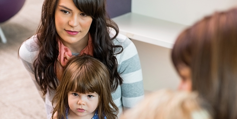 Woman with toddler in her lap listening to a story