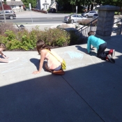 Three children drawing with chalk outisde the Ancaster branch 