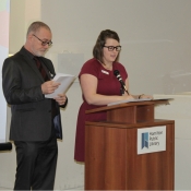 a photo of a male and female hosting an event behind a podium