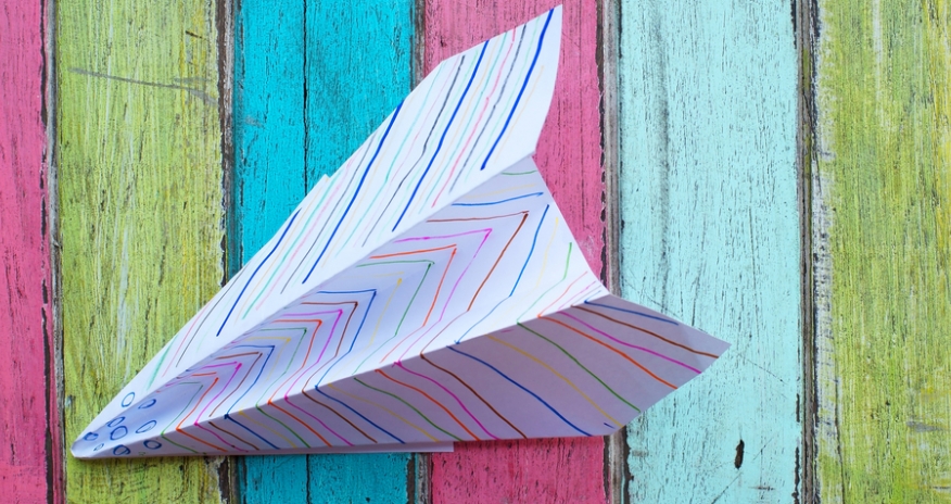 Paper Airplanes Closeup of a paper airplane on a colourful wood background