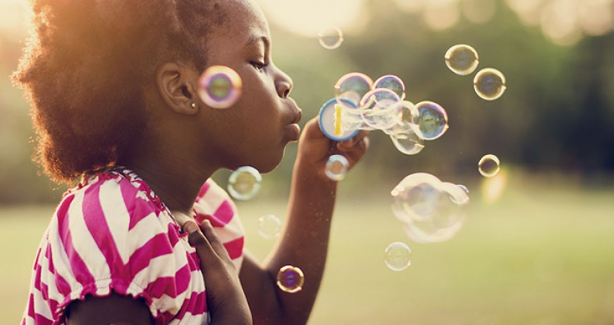 Patio Play girl blowing bubbles outdoors